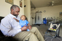 Andre Wiley holds his 7-month-old son Amir in he and his wife’s two-bedroom apartment in Union City, Calif., on Friday, April 3, 2015. Wiley, a